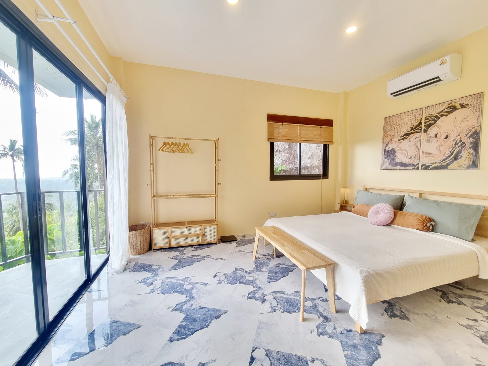 Sunlit bedroom with balcony view of palms