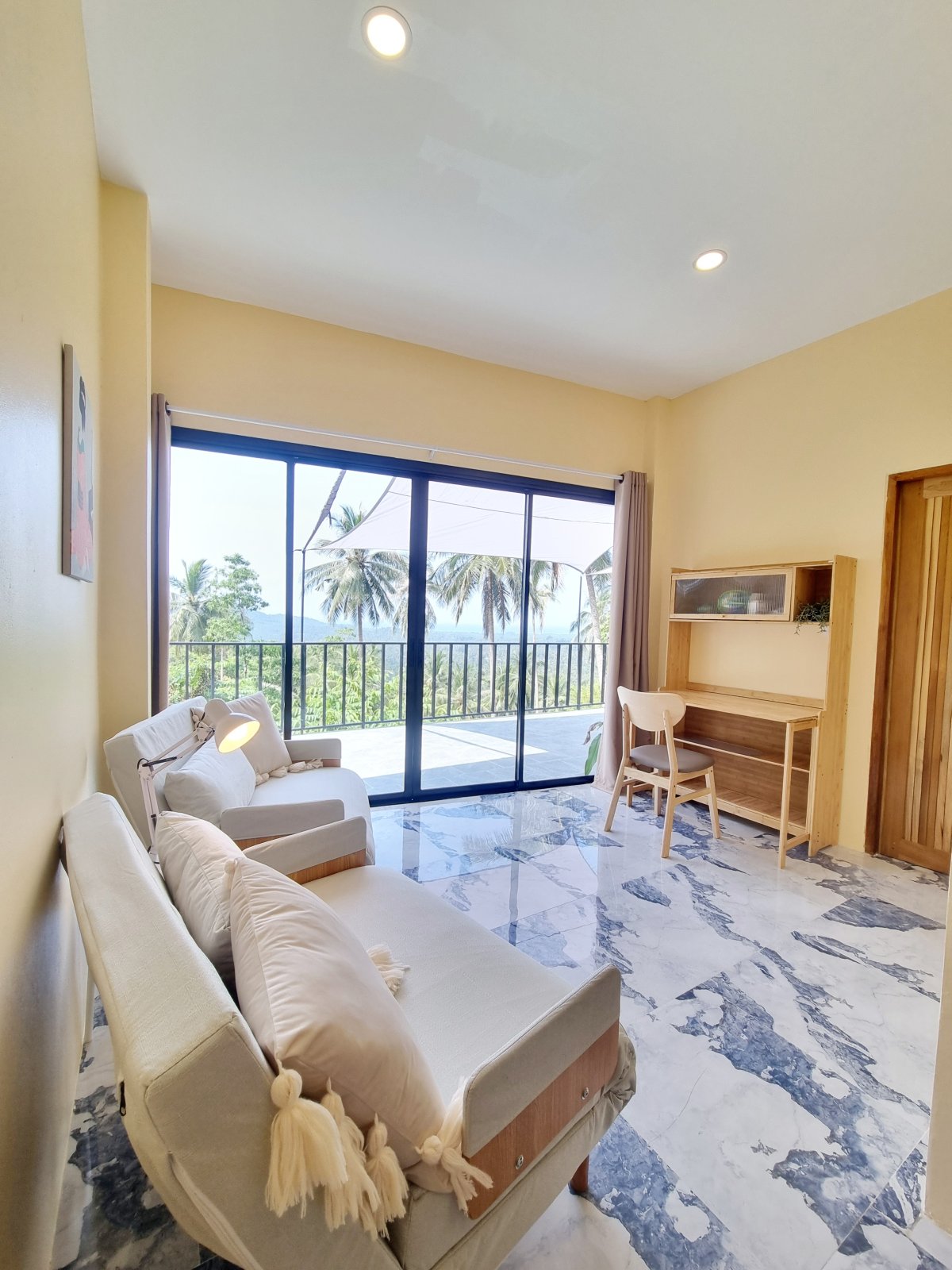 Living room with palm-view balcony and desk nook